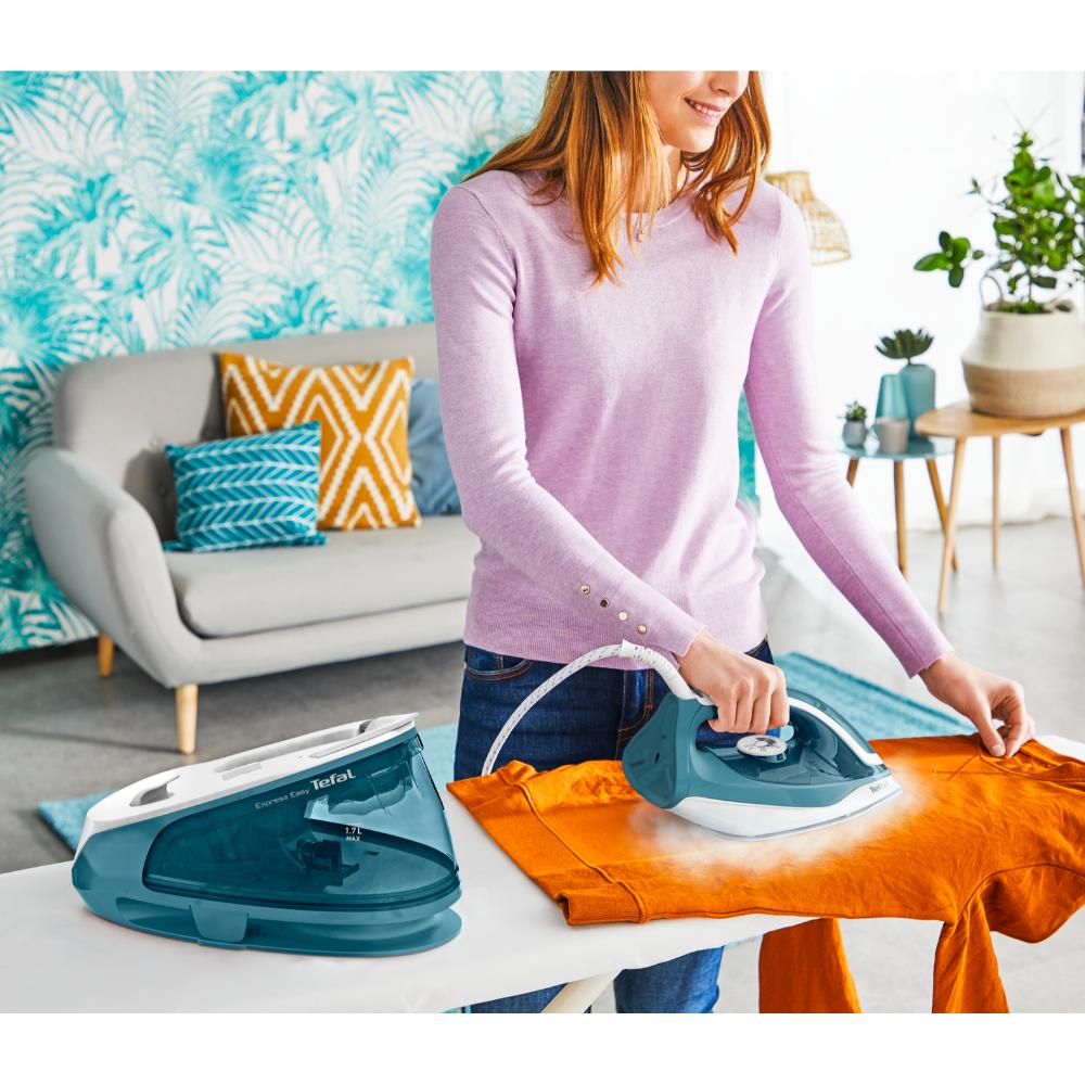 woman using steam iron on orange jumper - MyHouse