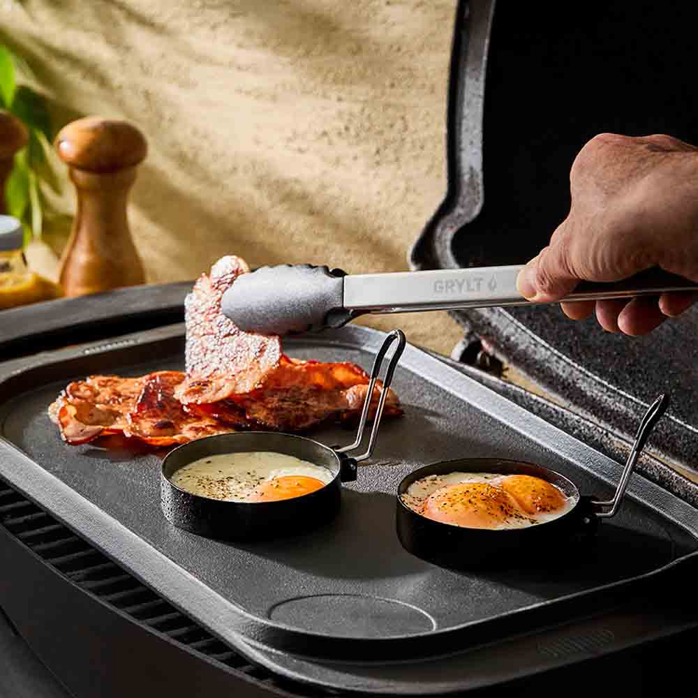 man cooking on the BBQ with steel egg rings with lever - MyHouse
