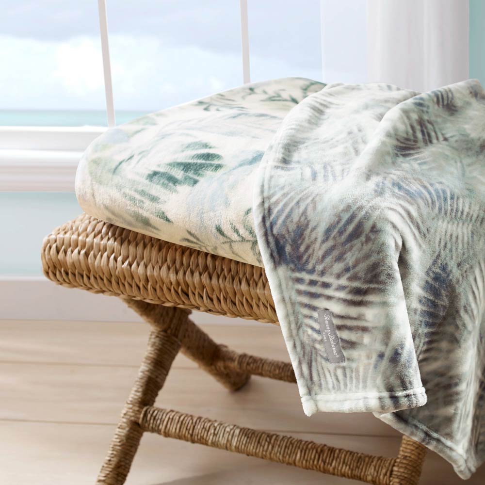 Tommy Bahama Wallpaper Leaves Throw Green folded on a chair at MyHouse