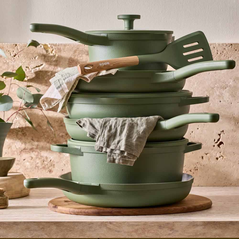 stack of green cookware on stone kitchen counter