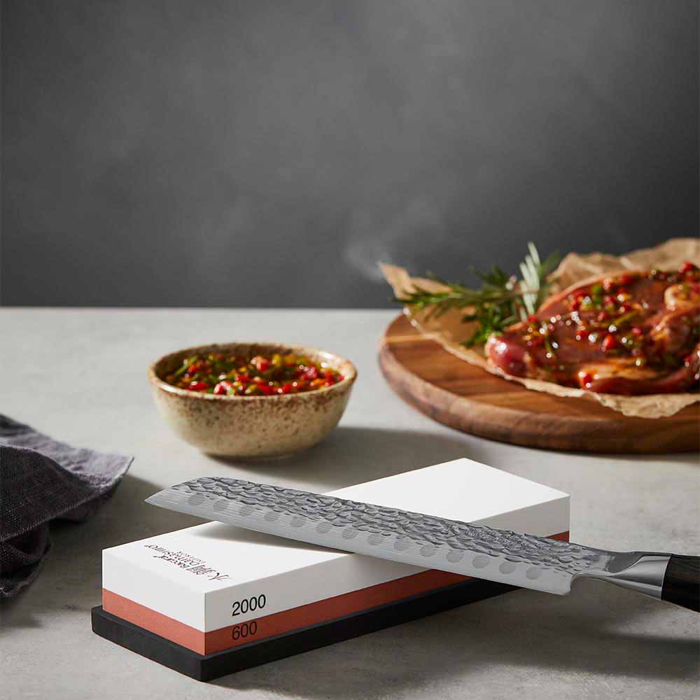 Knife sitting on top of a whetstone 600/2000 - MyHouse