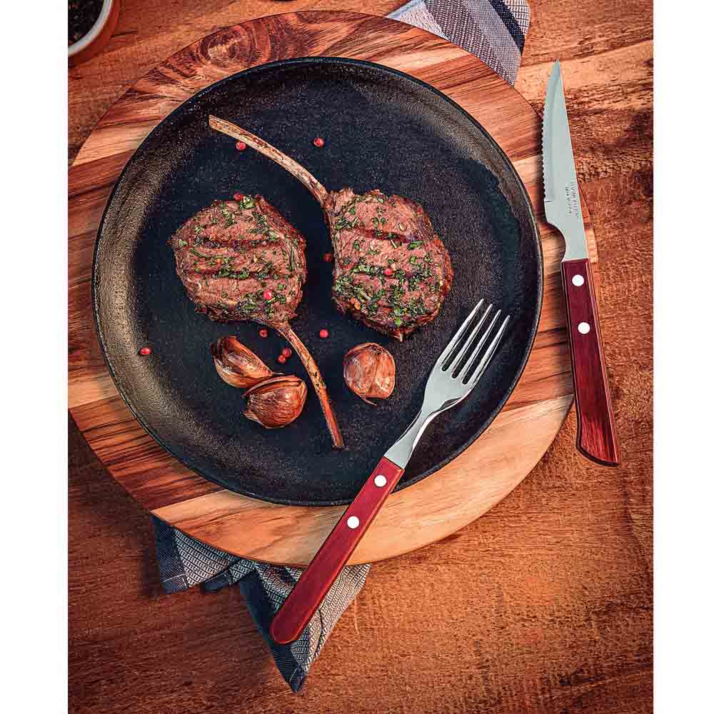 steak knife set with plate of cutlets on wooden table - MyHouse