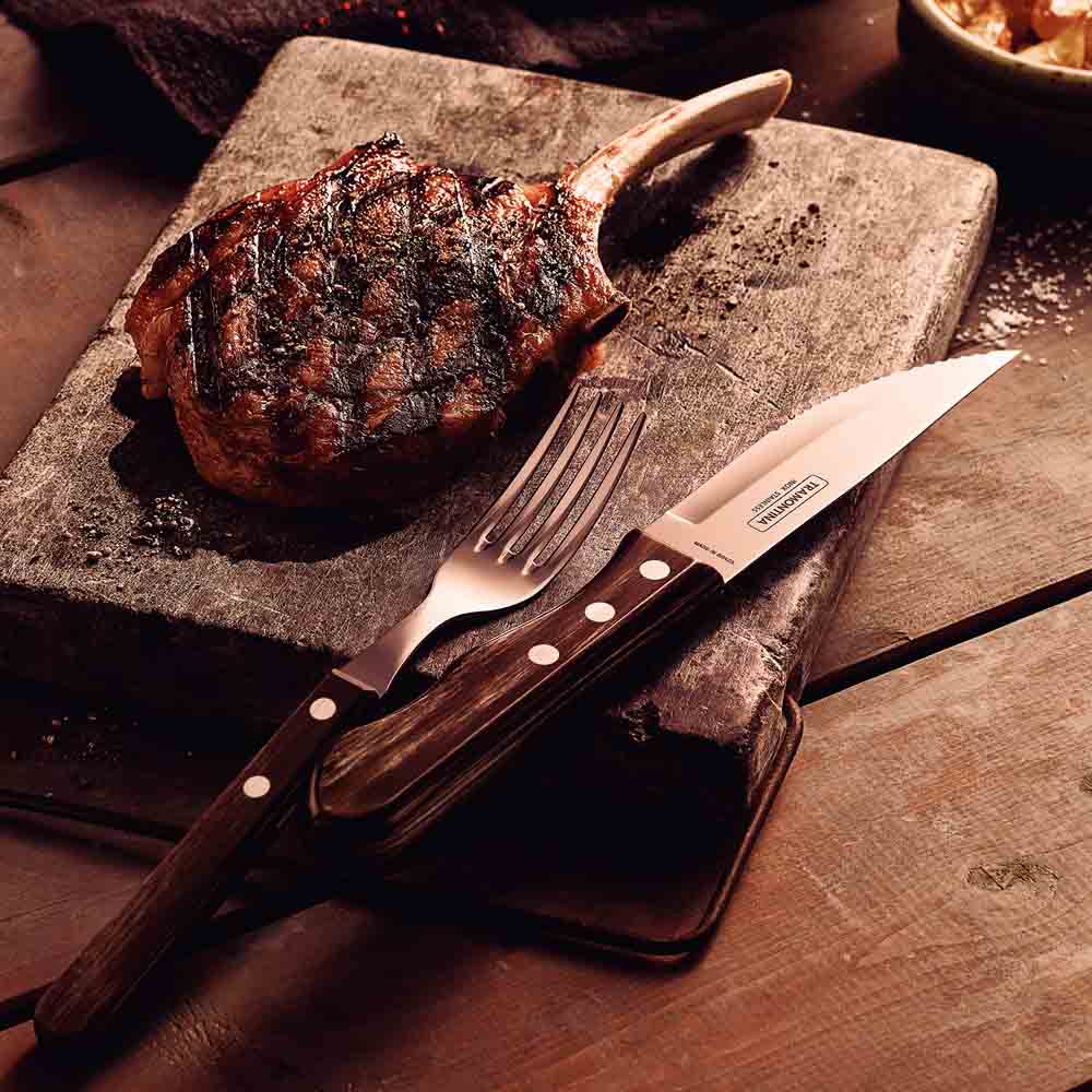steak knife and fork set with side of cutlet on wooden board - House