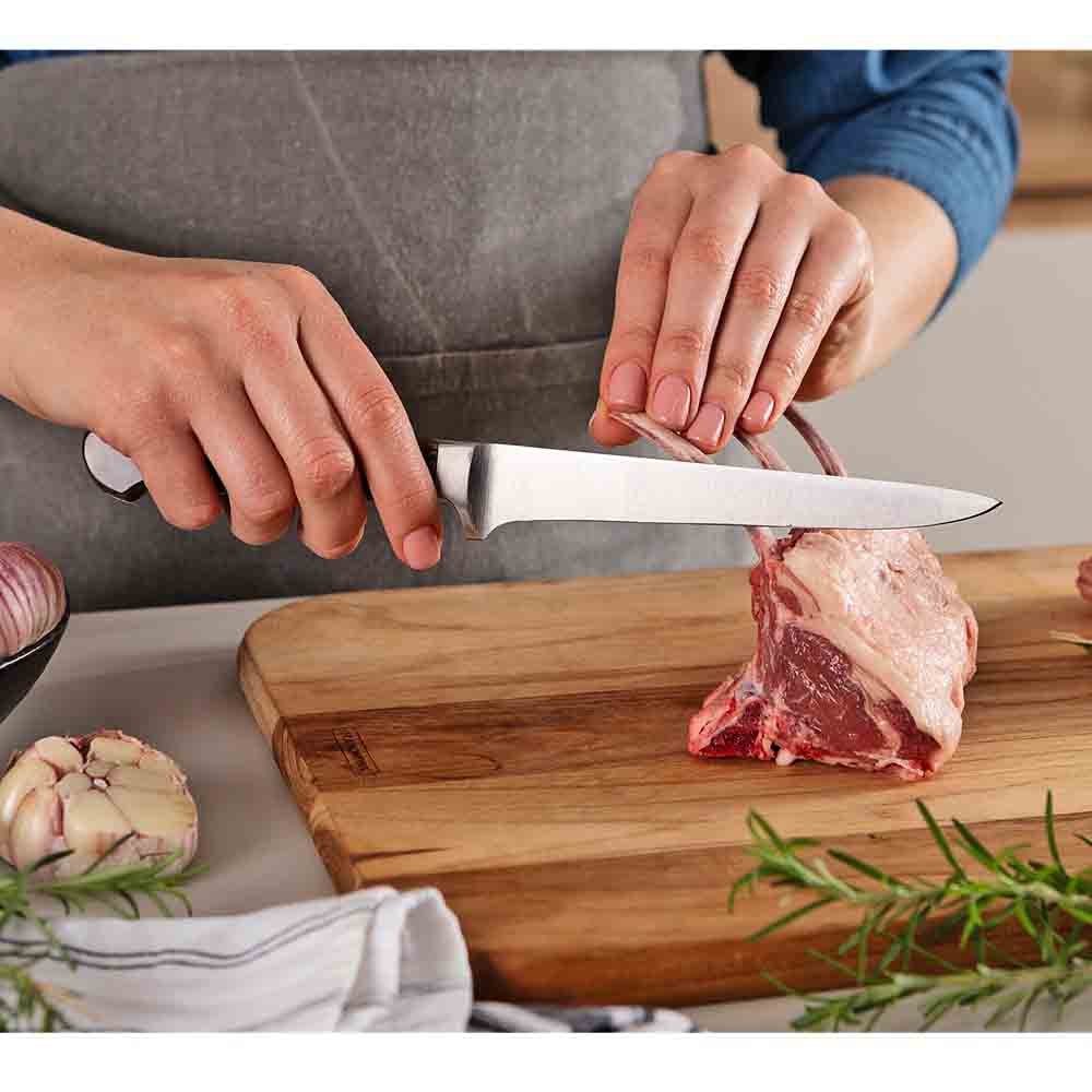 woman frenching rack of lamb with boning knife - MyHouse