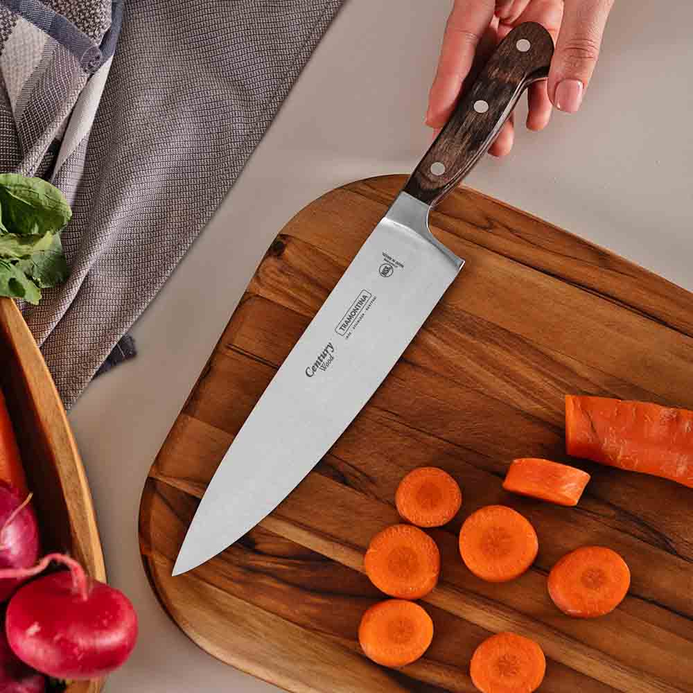 woman chopping carrot at kitchen counter with chef knife - MyHouse