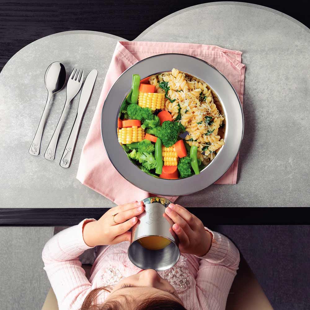 Child sitting at dinner table with meal and kids cutlery - MyHouse