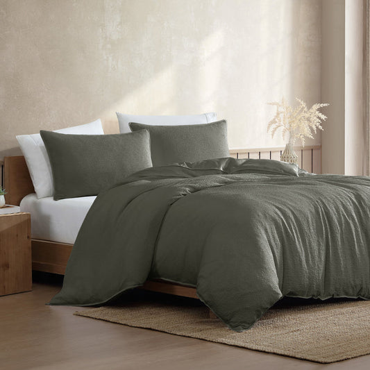 Bed with green bedding in a bedroom setting