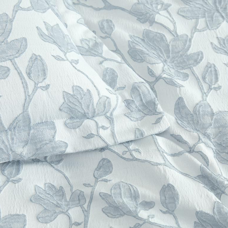 Floral patterned fabric with blue leaves on a white background
