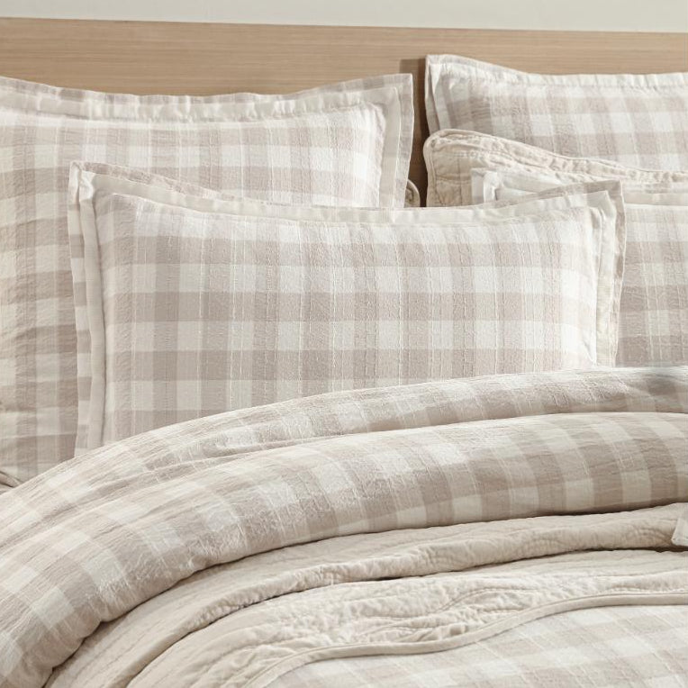 Checkered bedding set on a bed with a wooden headboard.