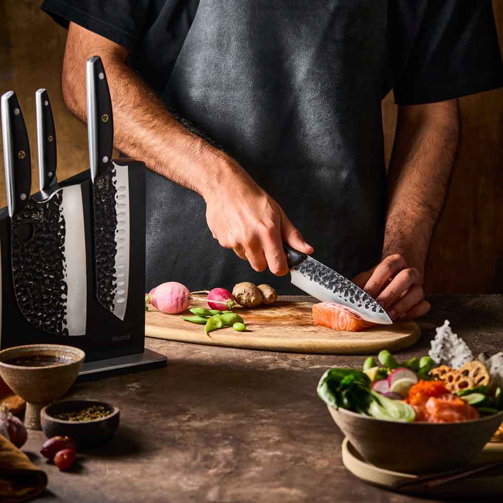 Man slicing salmon with Baccarat KUROI KIBA 7 Piece Knife Block at MyHouse