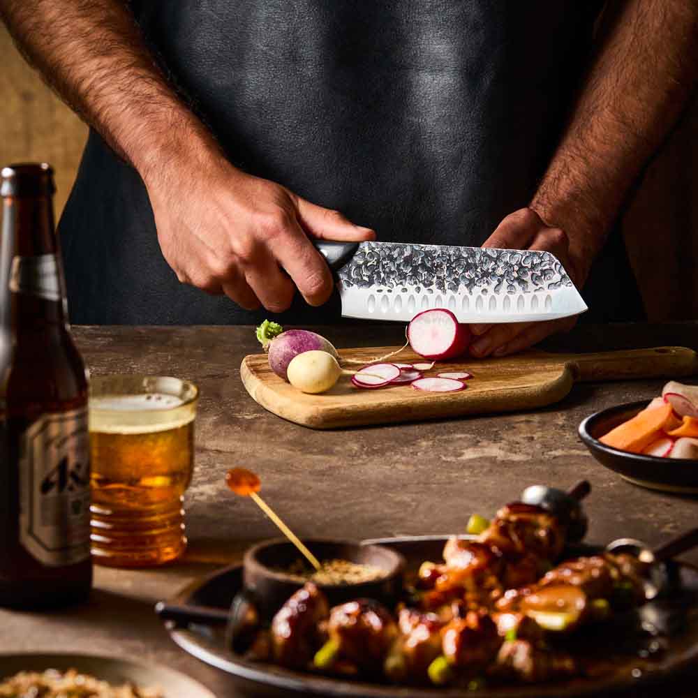 Man slicing radish with Baccarat KUROI KIBA Santoku Knife 18cm at MyHouse
