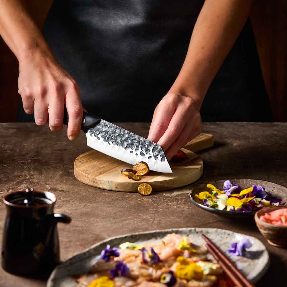 Woman slicing eggplant with Baccarat KUROI KIBA Santoku Knife 14cm at MyHouse