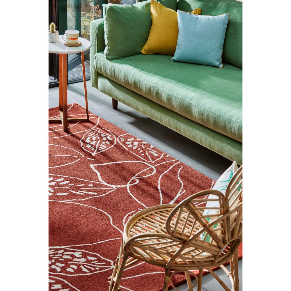 red leaf wool rug with green couch in loungeroom - MyHouse