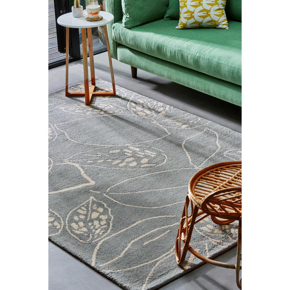 blue leaf wool rug with green couch in loungeroom - MyHouse