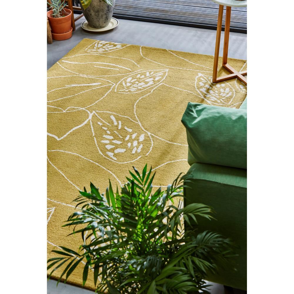 yellow leaf wool rug with green couch in loungeroom - MyHouse